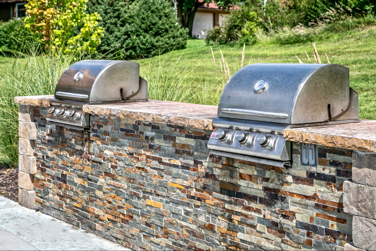Outdoor picnic area with community grills and fireplaces at Club at Highland Park Apartments, Omaha, NE