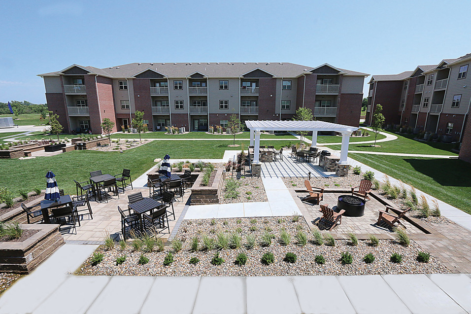 an outdoor area with a pavilion and tables in front of an apartment building