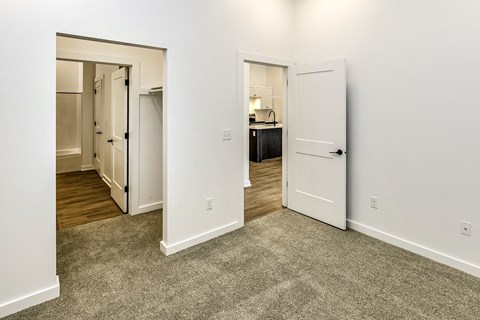 a bedroom with a door to a bathroom and a living room