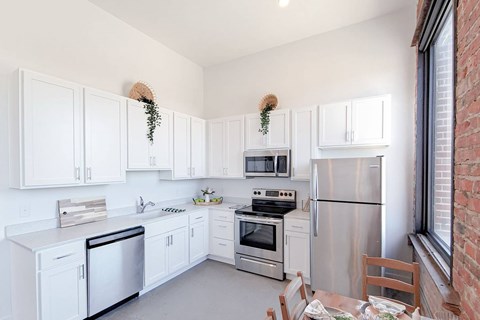 A kitchen with white cabinets and stainless steel appliances.