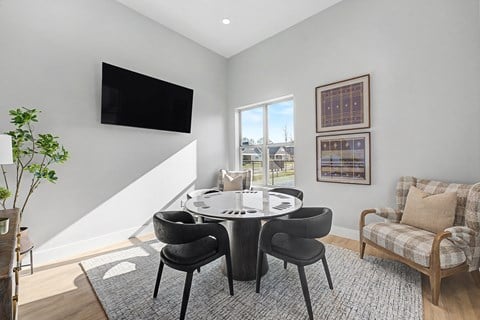 A modern dining room with a round table and chairs.