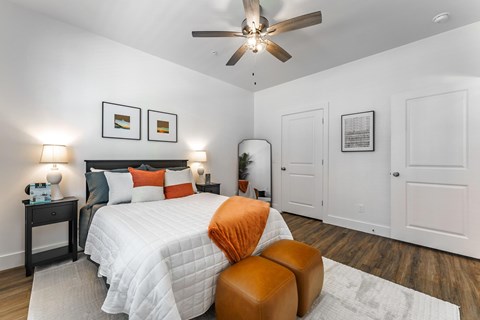 A bedroom with a large bed and a ceiling fan.