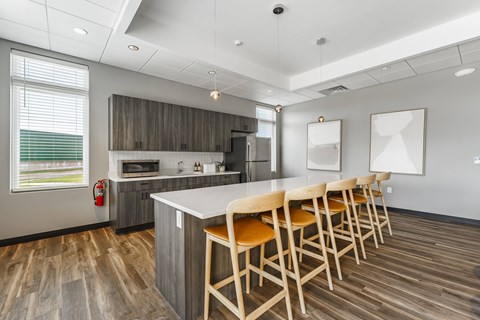A kitchen with a long table and chairs.
