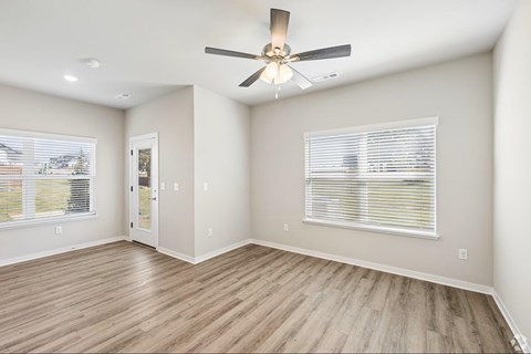 A room with a ceiling fan and a window with blinds.
