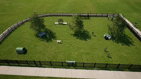 A dog park with a black fence and a dog walking on the grass.