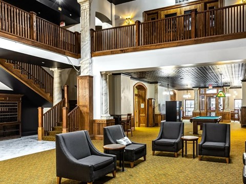A large room with a pool table and chairs.