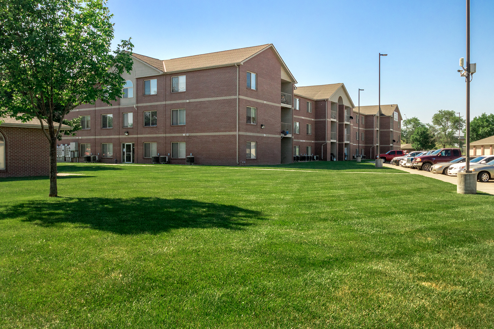 a large green lawn in front of an apartment building