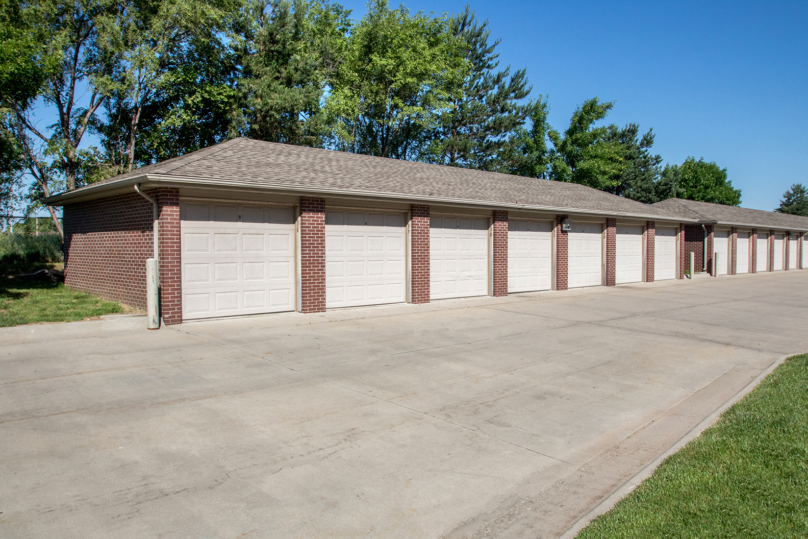 a row of white garage doors on a brick building