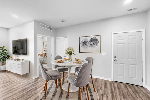 A dining room with a white table and grey chairs.