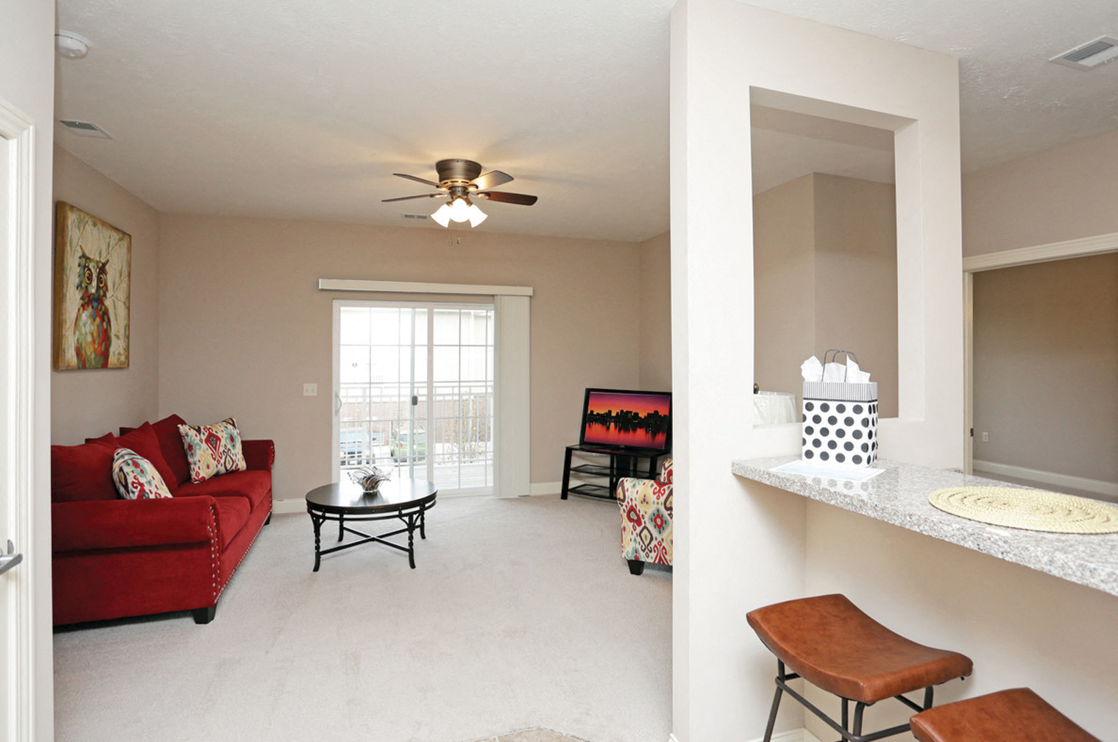 a living room with a red couch and a ceiling fan