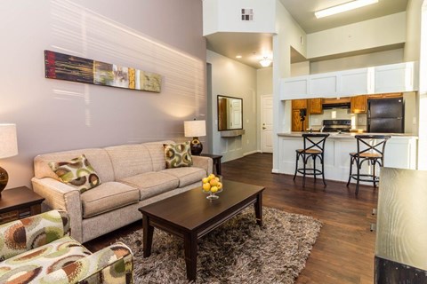 A living room with a couch, a coffee table, and a painting on the wall.