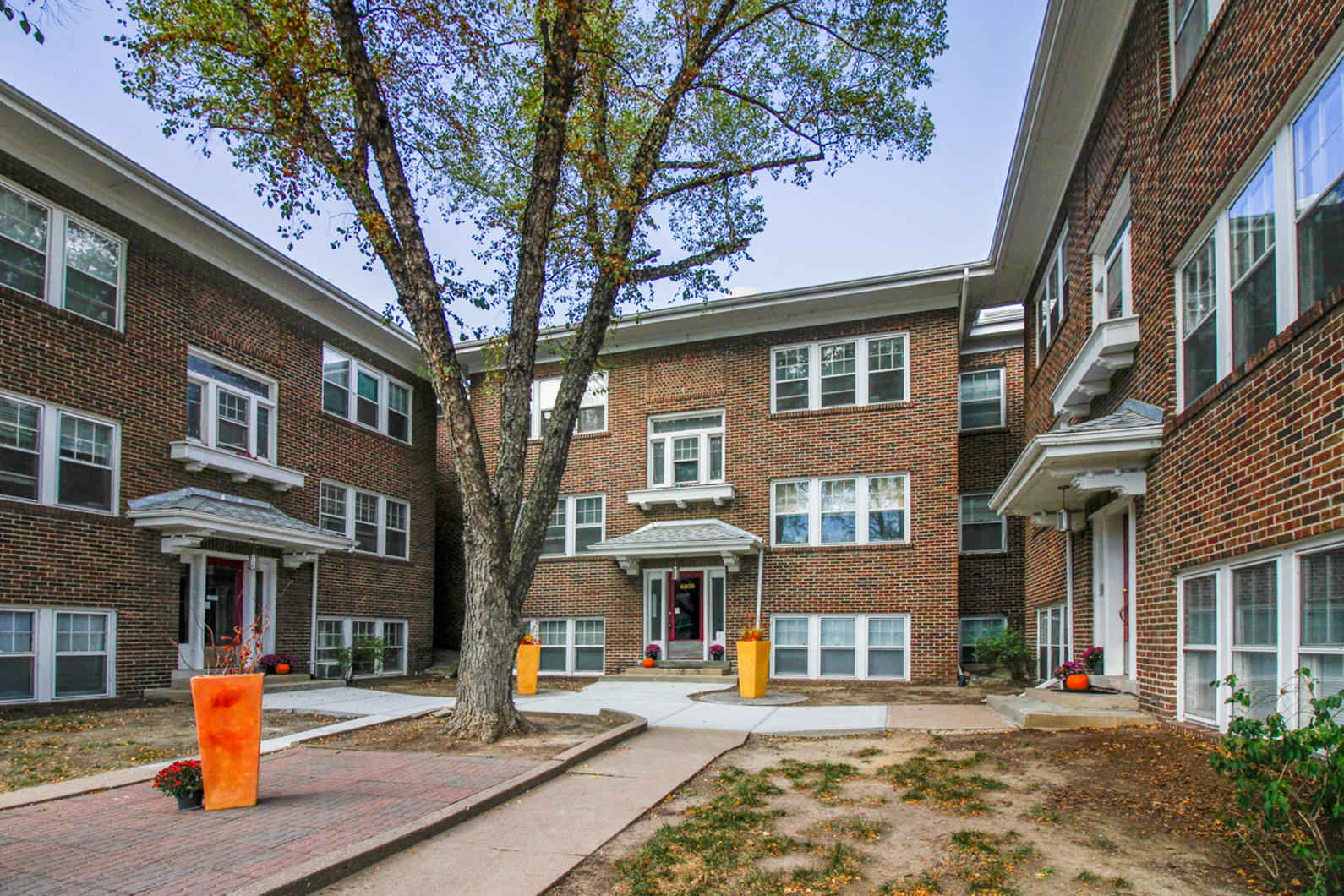 a brick building with a tree in front of it