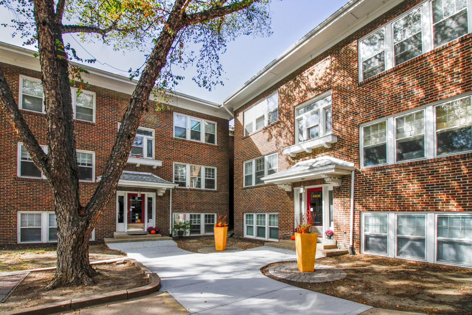 a brick building with a tree in front of it
