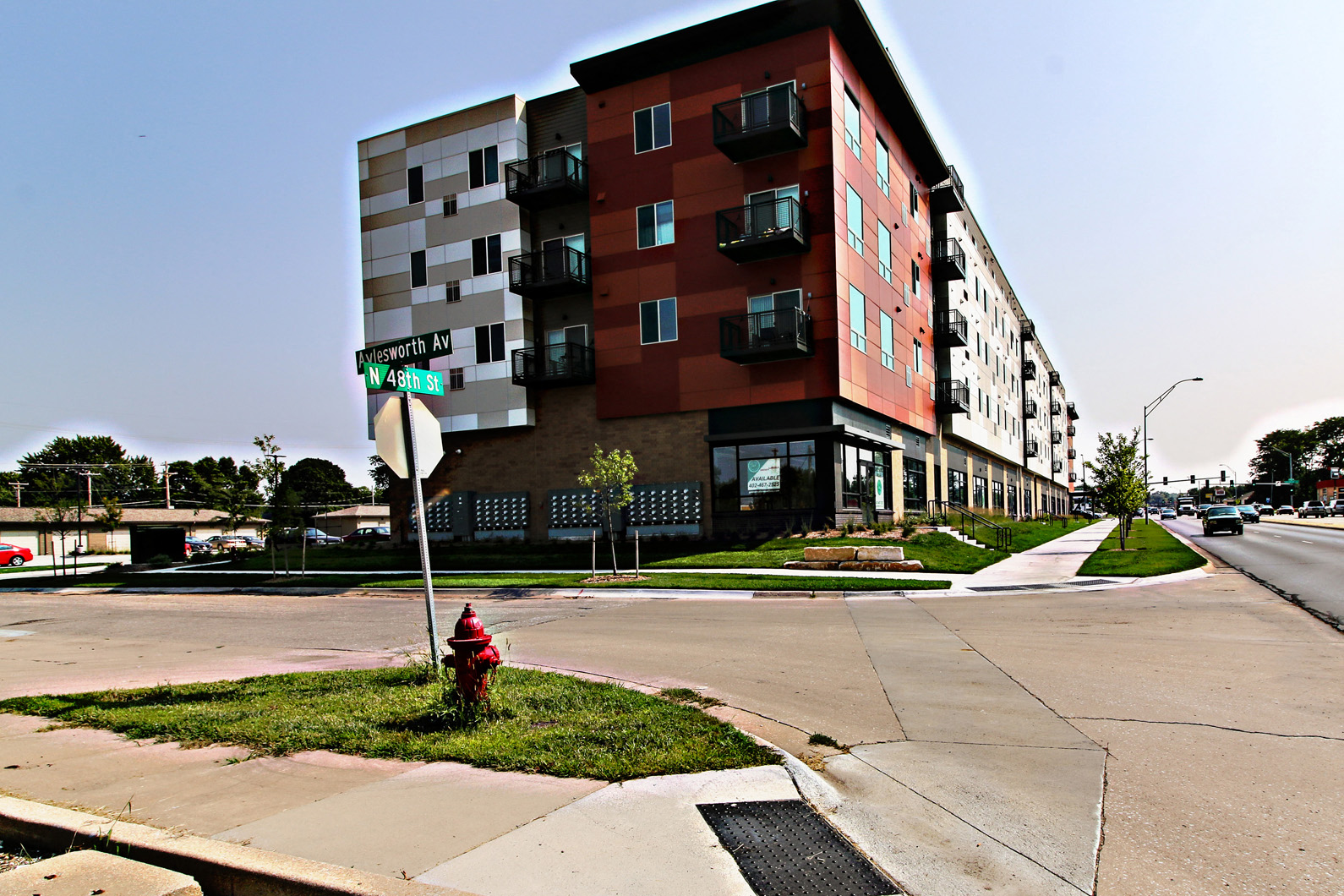 an apartment building on the corner of a street with a fire hydrant