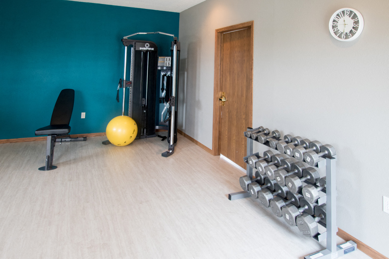 a home gym with a blue wall and a yellow ball on the floor