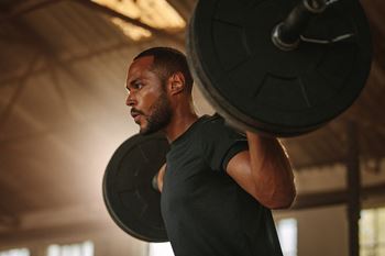 a man lifting a barbell in a gym