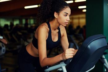 a woman biking on a bike in a gym