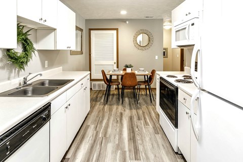 a kitchen with white appliances and a dining table