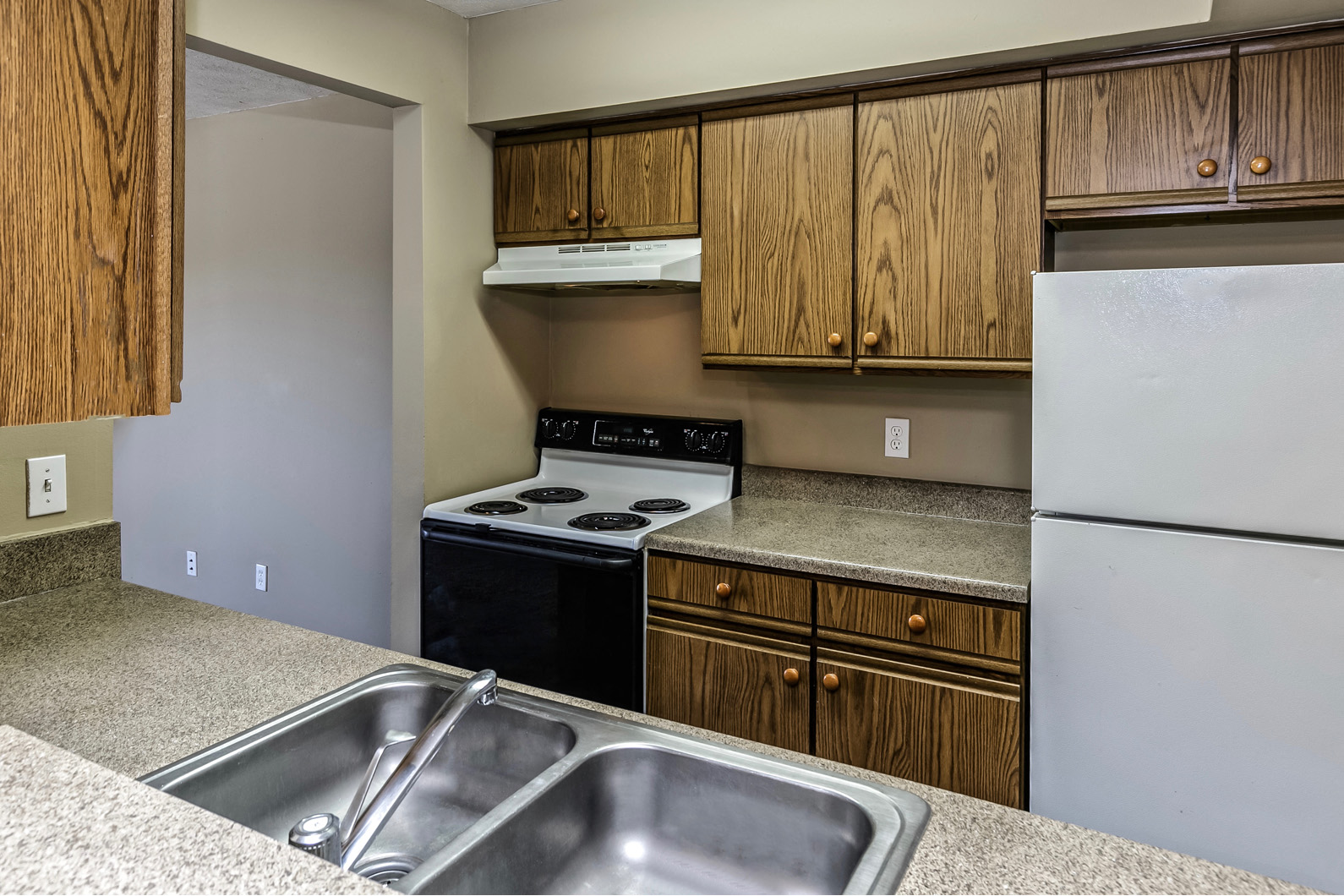 an empty kitchen with a sink stove and refrigerator