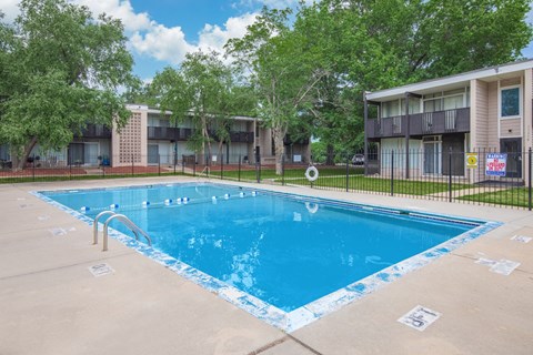 A swimming pool surrounded by a fence and trees.