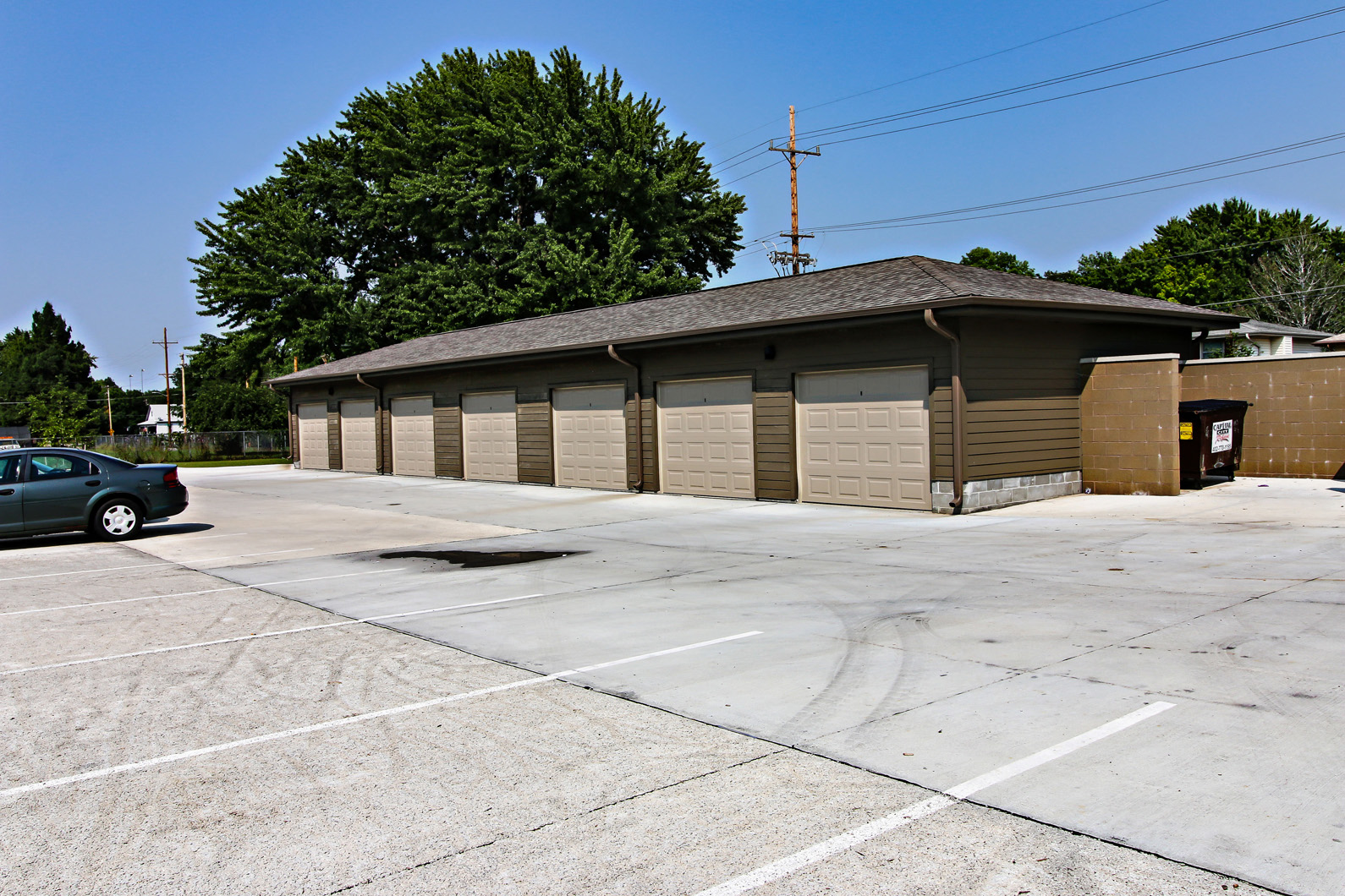 an empty parking lot in front of a building with closed garage doors