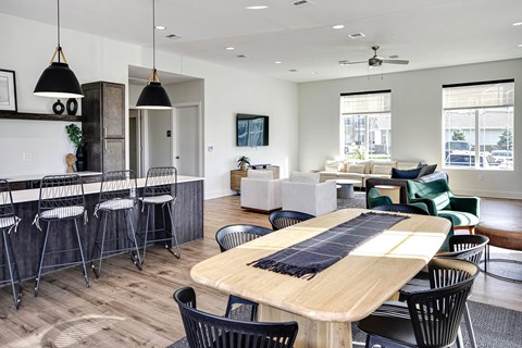 A modern dining room with a wooden table and black chairs.