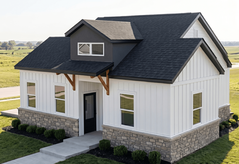 A white house with a black roof and a stone foundation.