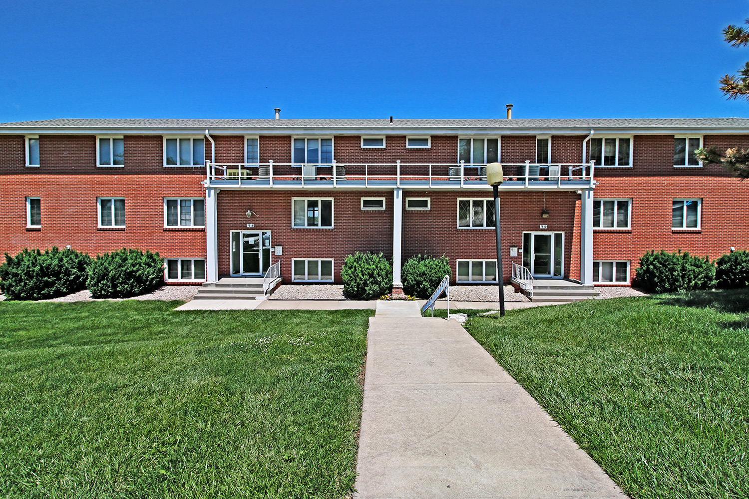 a large brick building with a sidewalk in front of it