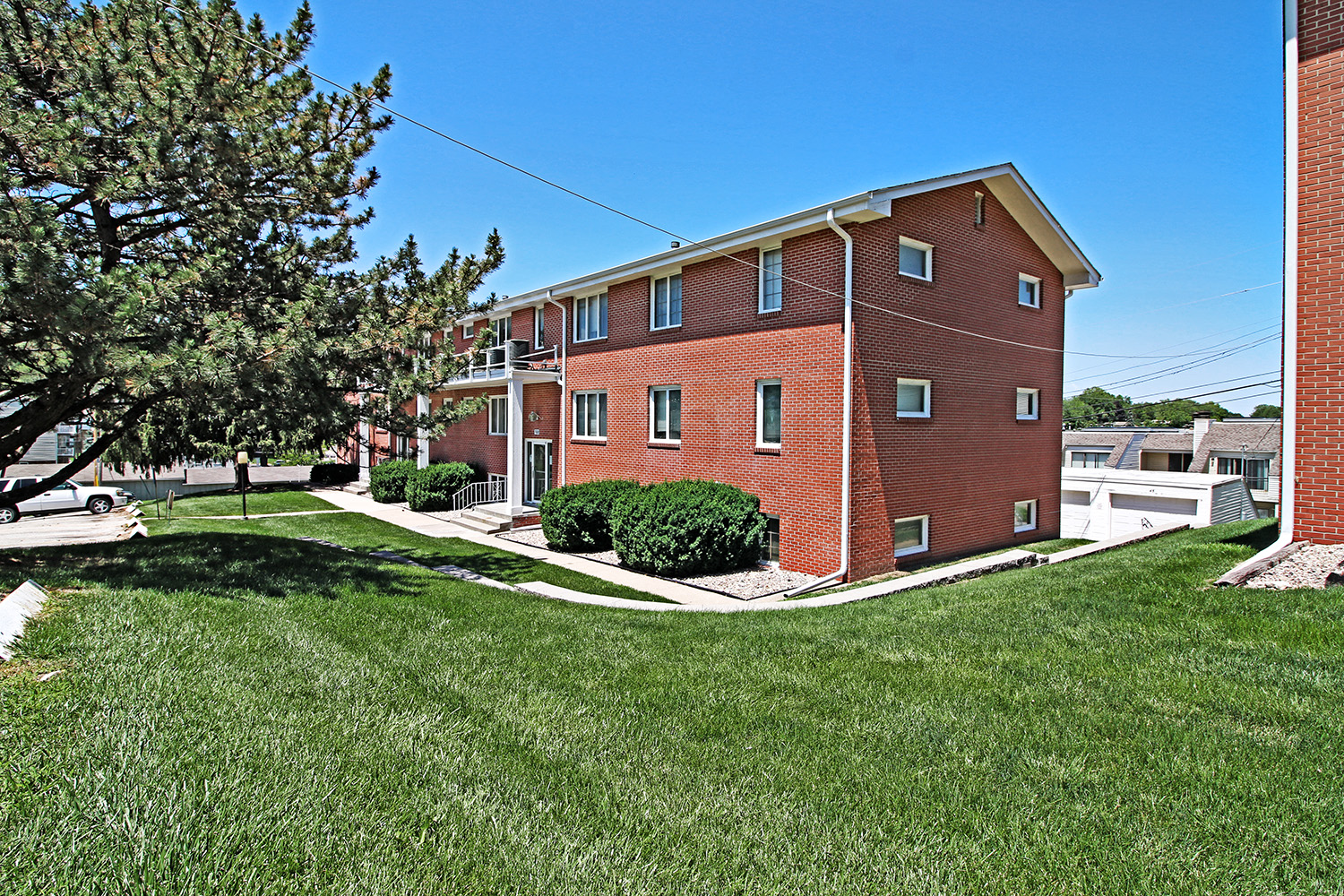 a red brick apartment building with a yard in front of it