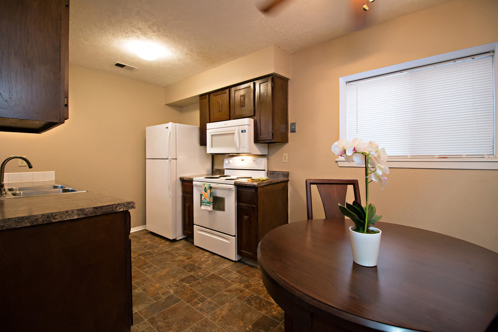 a kitchen with a table and a refrigerator and a sink