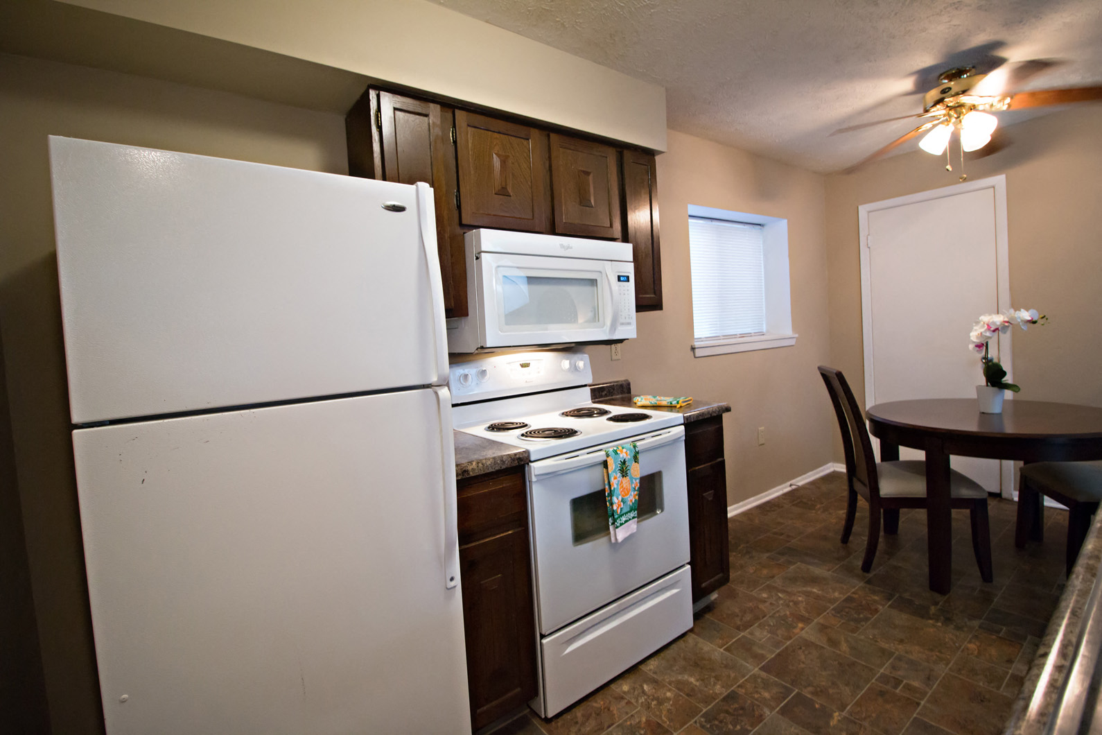 a kitchen with white appliances and a dining room table