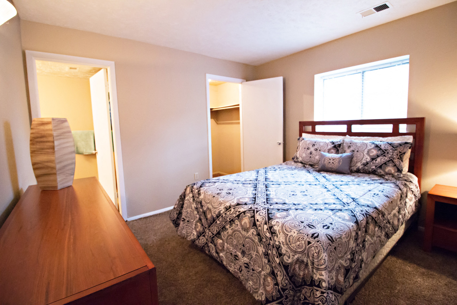 a bedroom with a bed and a dresser and a closet