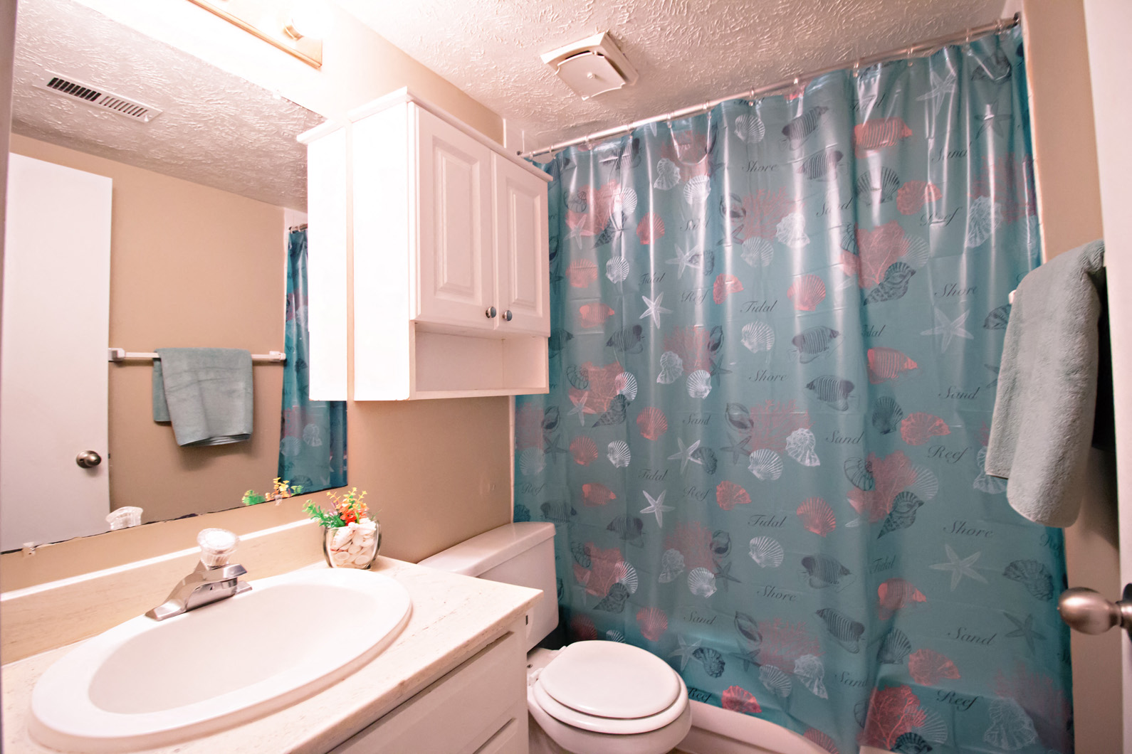 a bathroom with a sink and toilet and a shower curtain