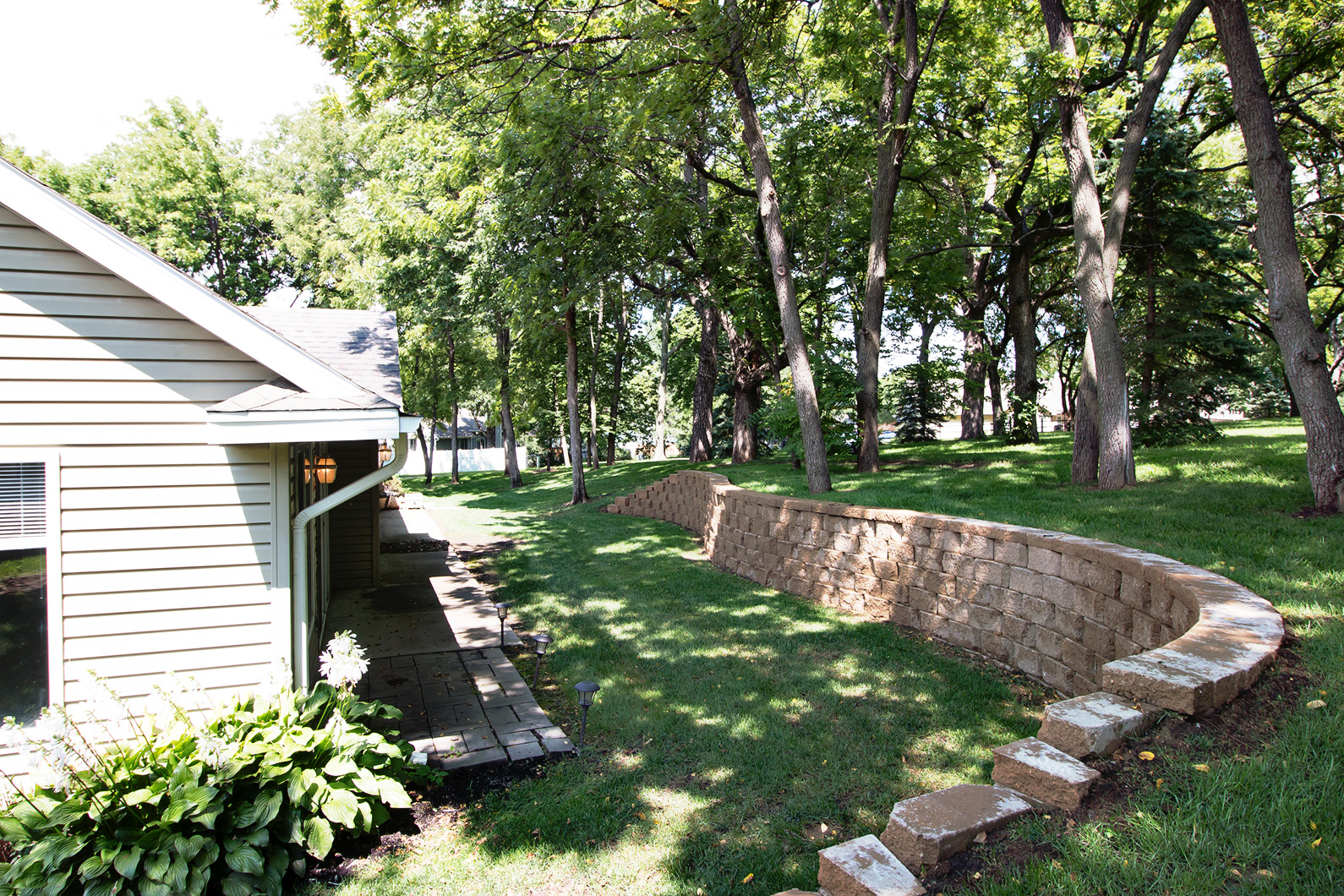 a retaining wall in a yard next to a house