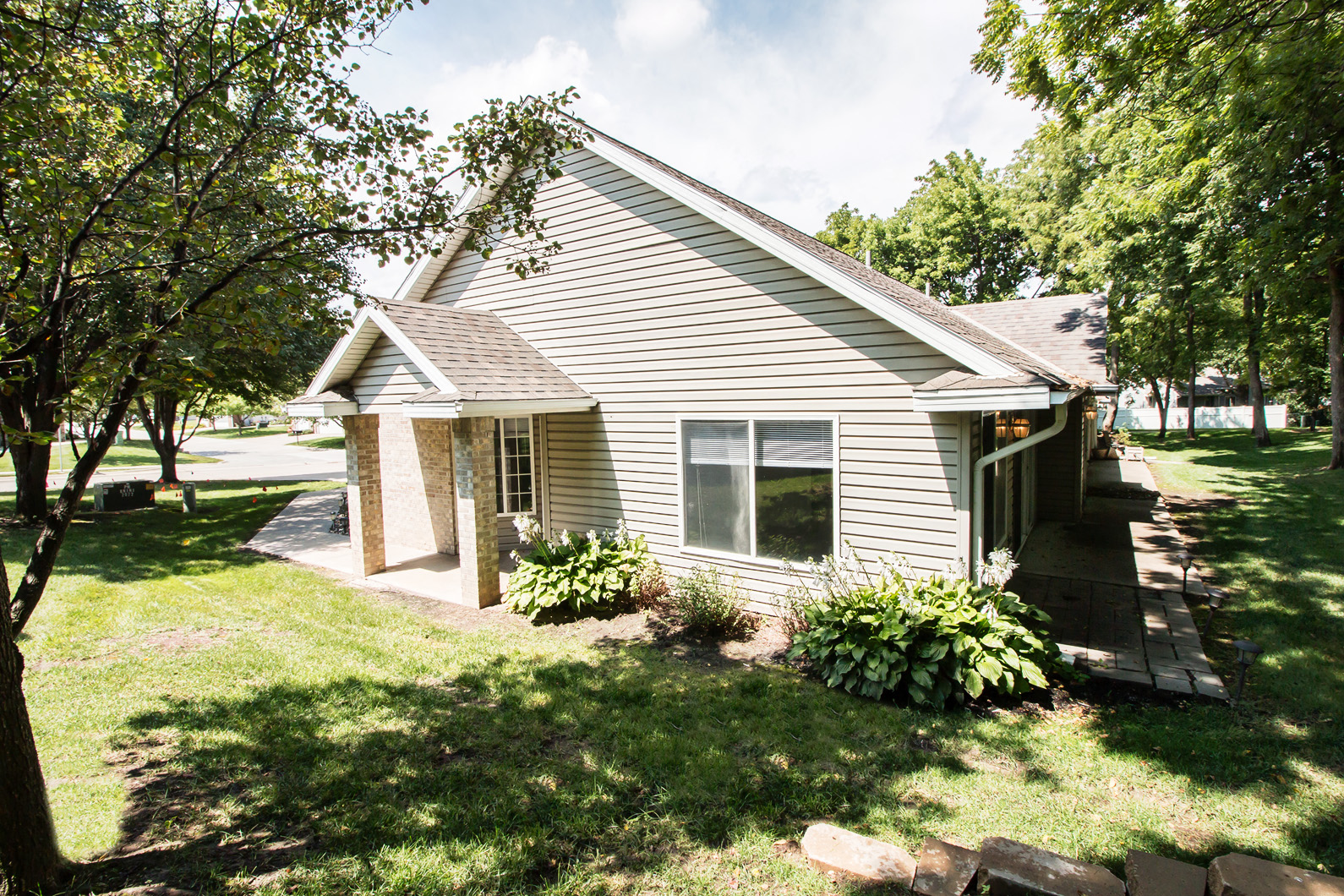 a small gray house with a porch and a lawn