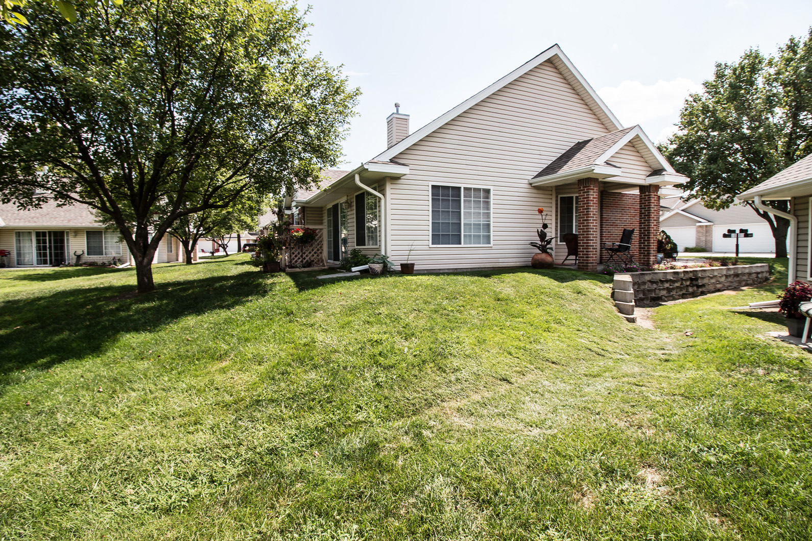 a white house with a lawn and a tree