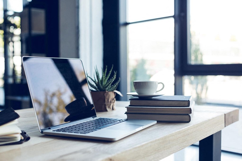 an open laptop computer sitting on top of a wooden desk