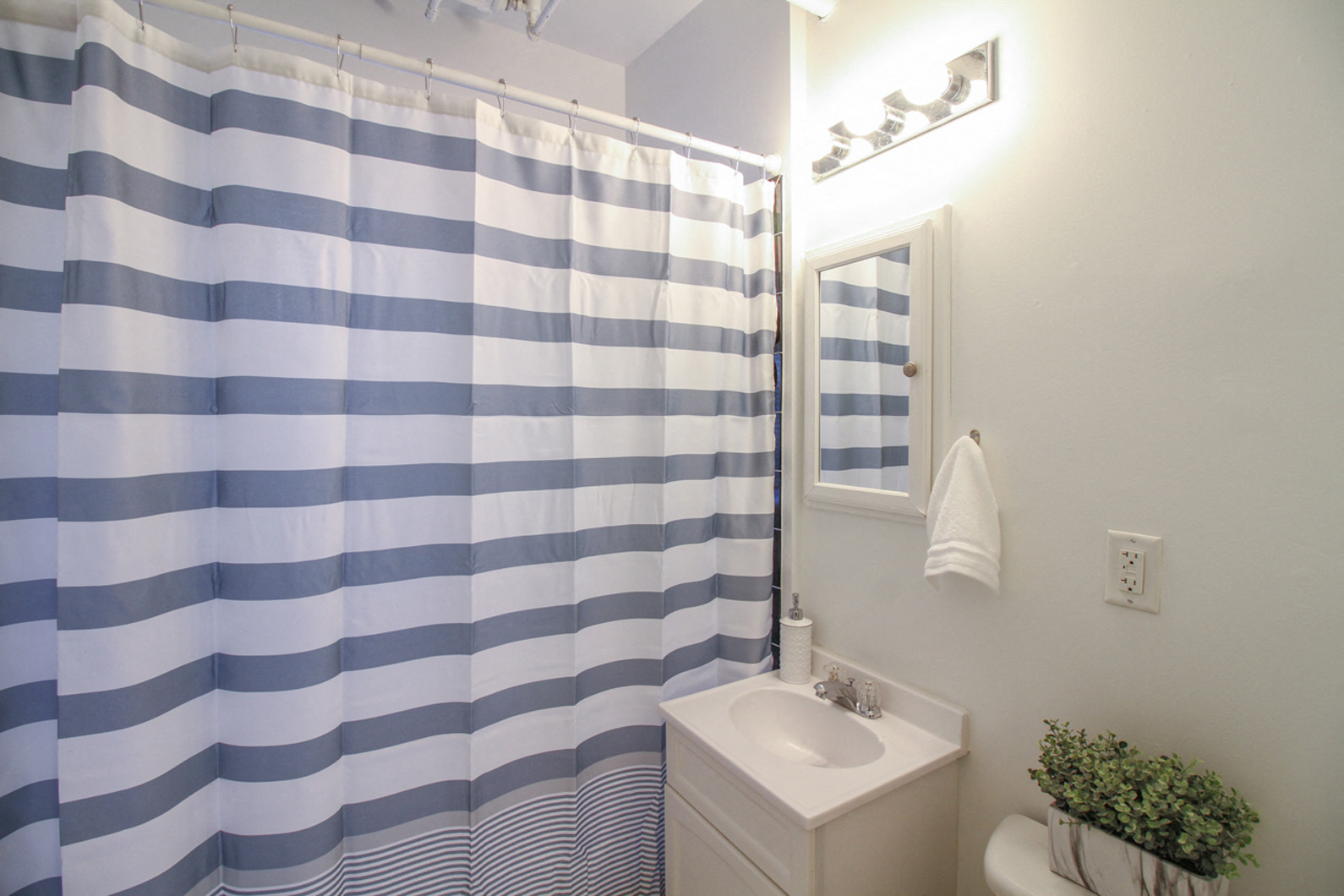 a bathroom with a blue and white striped shower curtain