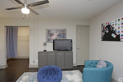 A living room with a blue chair and a television.