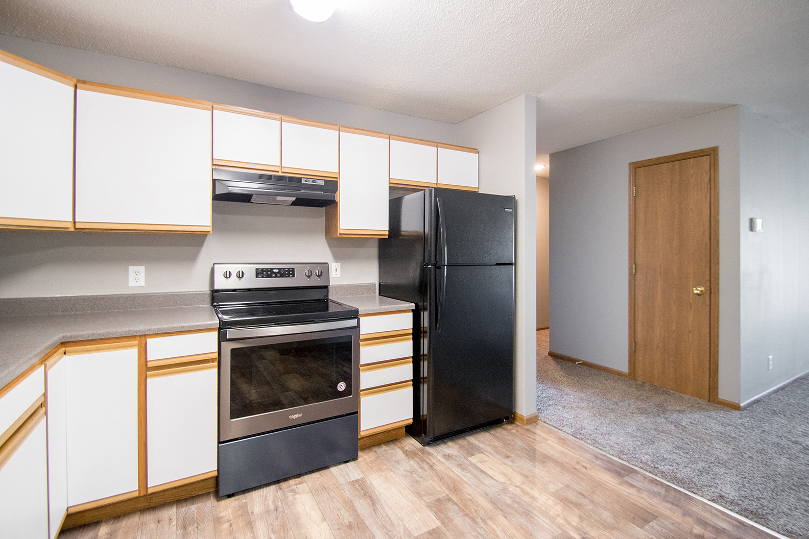 an empty kitchen with black appliances and white cabinets