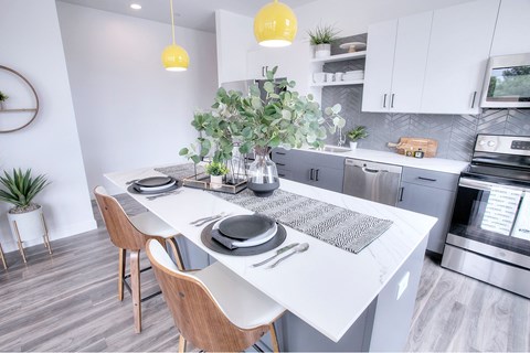 A modern kitchen with a dining table and chairs.