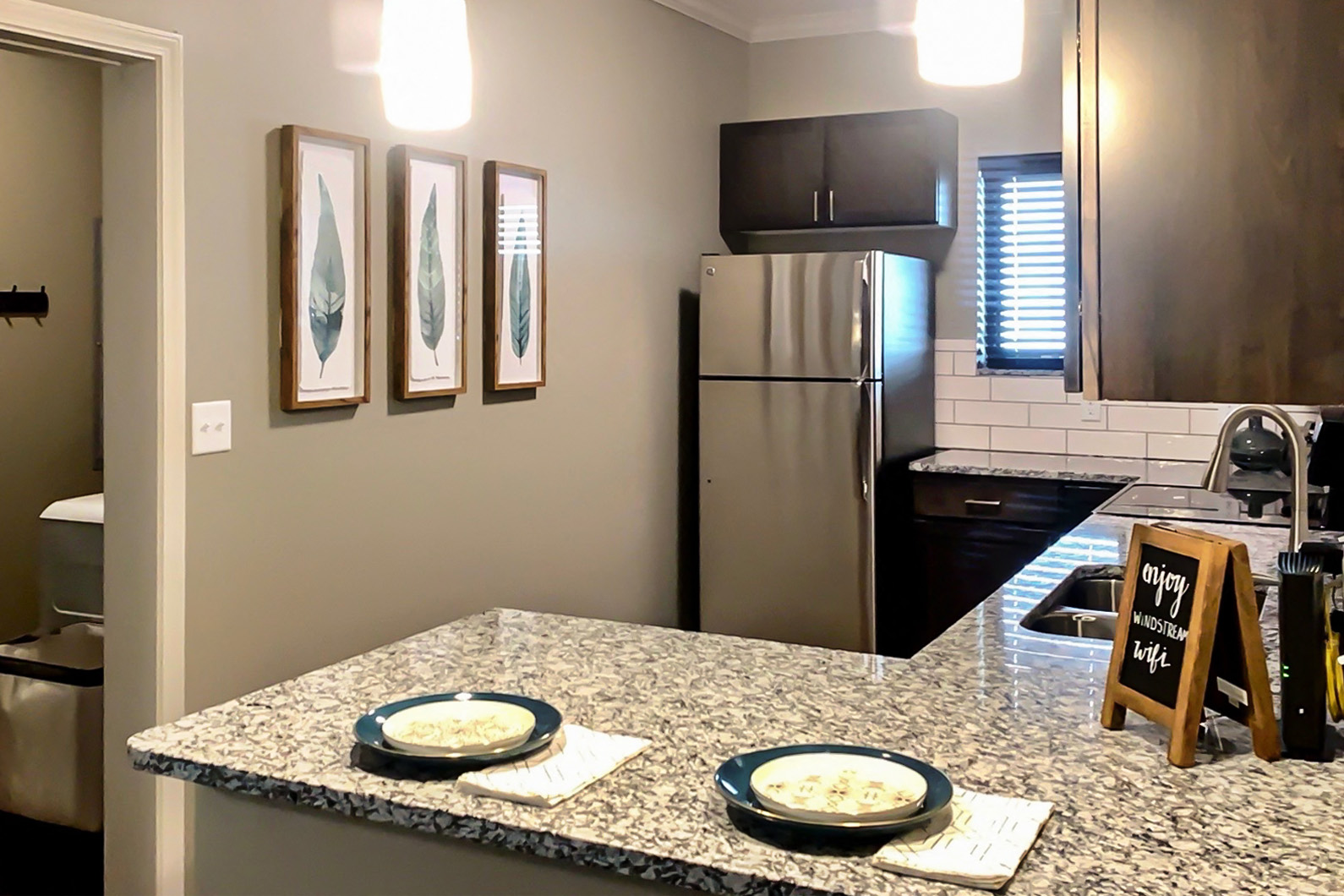a kitchen with a granite counter top and a stainless steel refrigerator