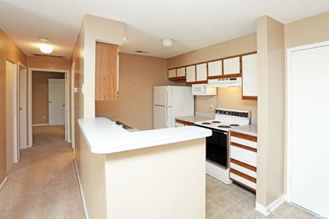 A kitchen with a white counter and brown cabinets.