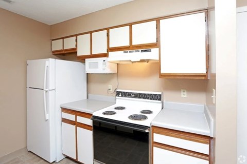 A kitchen with a white refrigerator, stove, and oven.