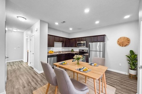 A modern kitchen with a dining table set for two.