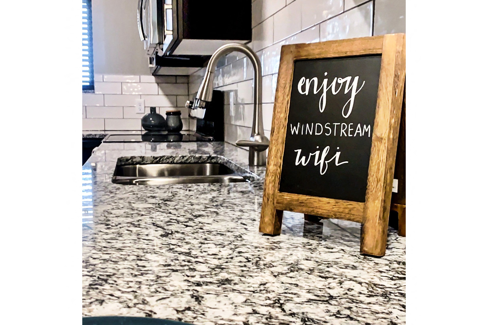 a chalkboard sign sitting on the counter in a kitchen