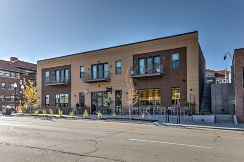 A modern building with a balcony and a tree in front.