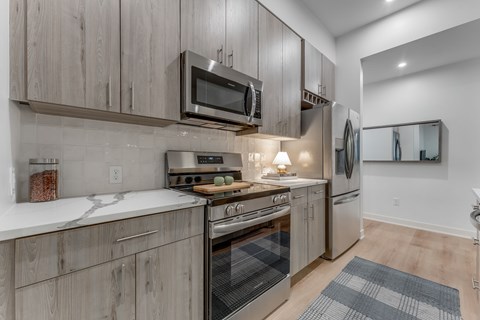 A modern kitchen with wooden cabinets and stainless steel appliances.
