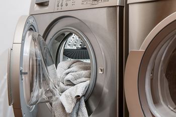 A washing machine with a grey towel in the drum.