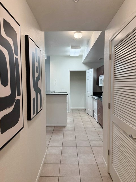 A hallway with two black and white paintings on the wall.